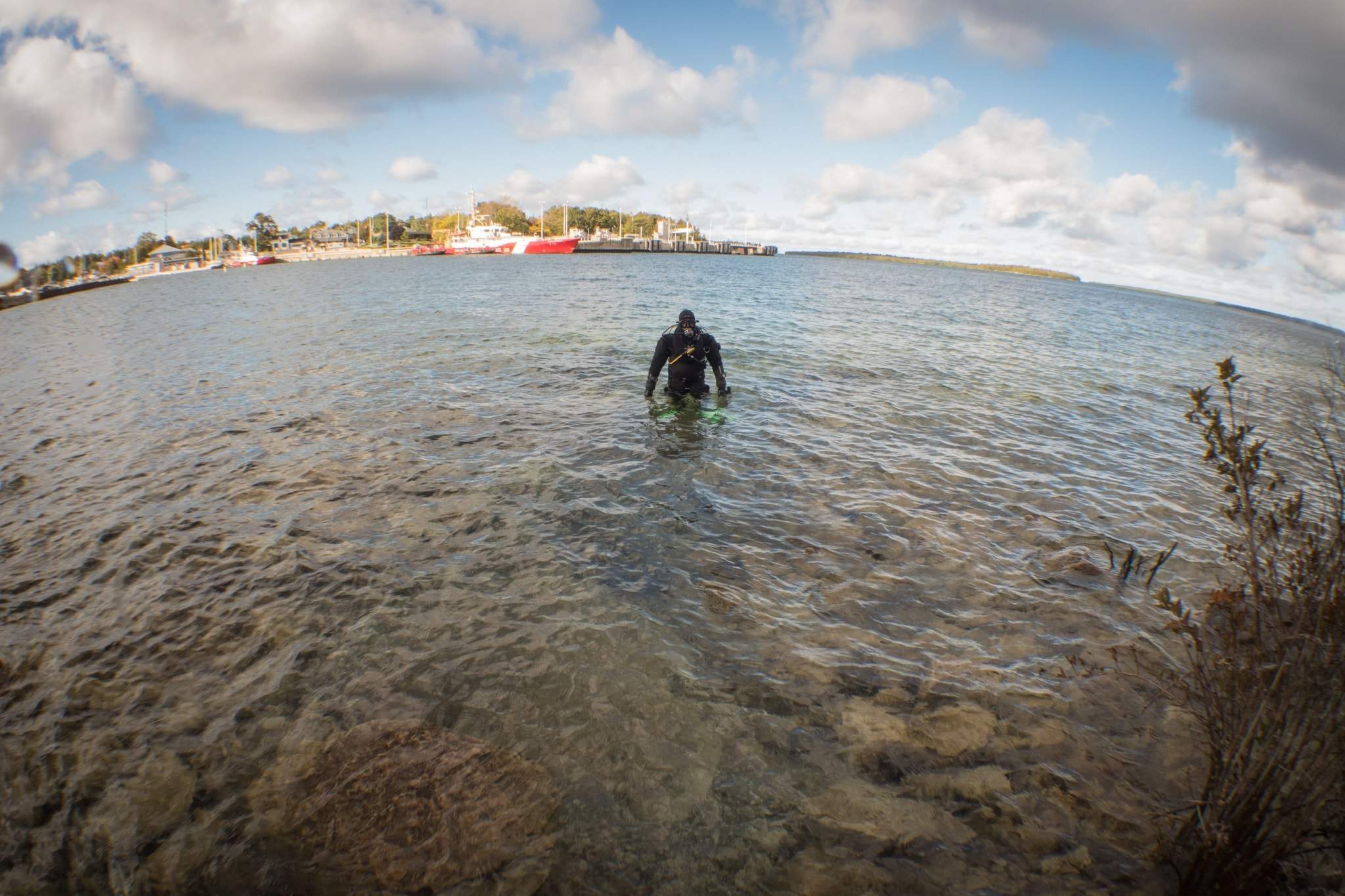 23 0 a scuba diver in a drysuit enters the water in tobermory