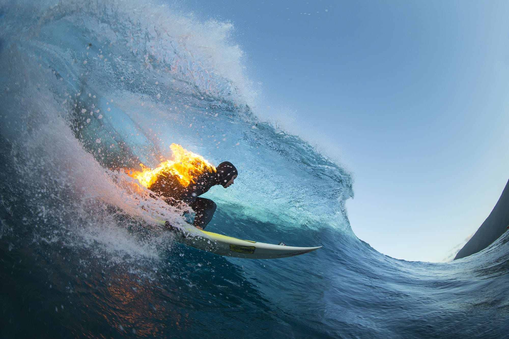 jamie obrien surfs whilst lit on fire, at teahupoo, tahiti.