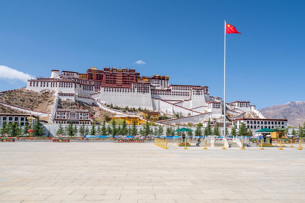 西藏布达拉宫前的广场和飘扬的五星红旗摄影照片