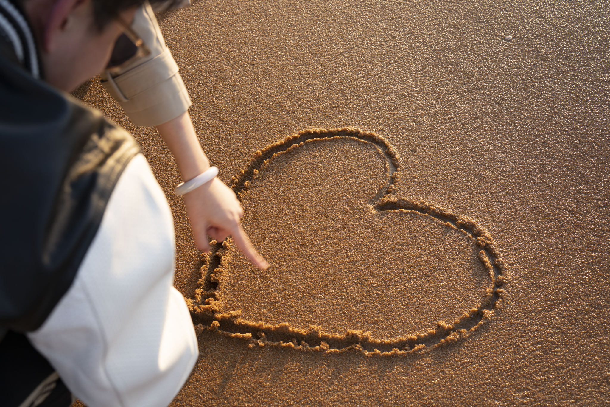 沙滩上的情侣画爱心