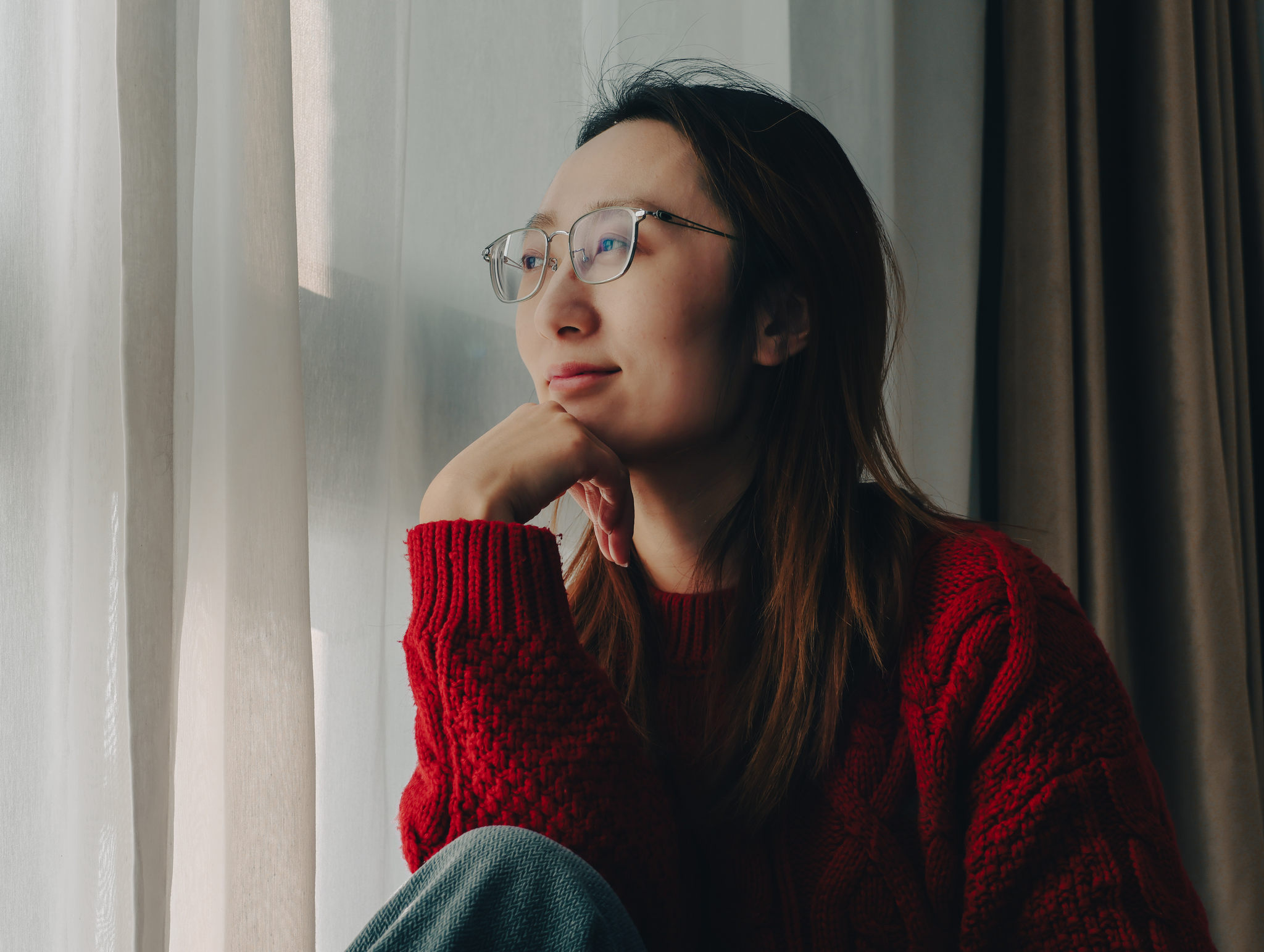 坐在家里靠窗的年轻女子