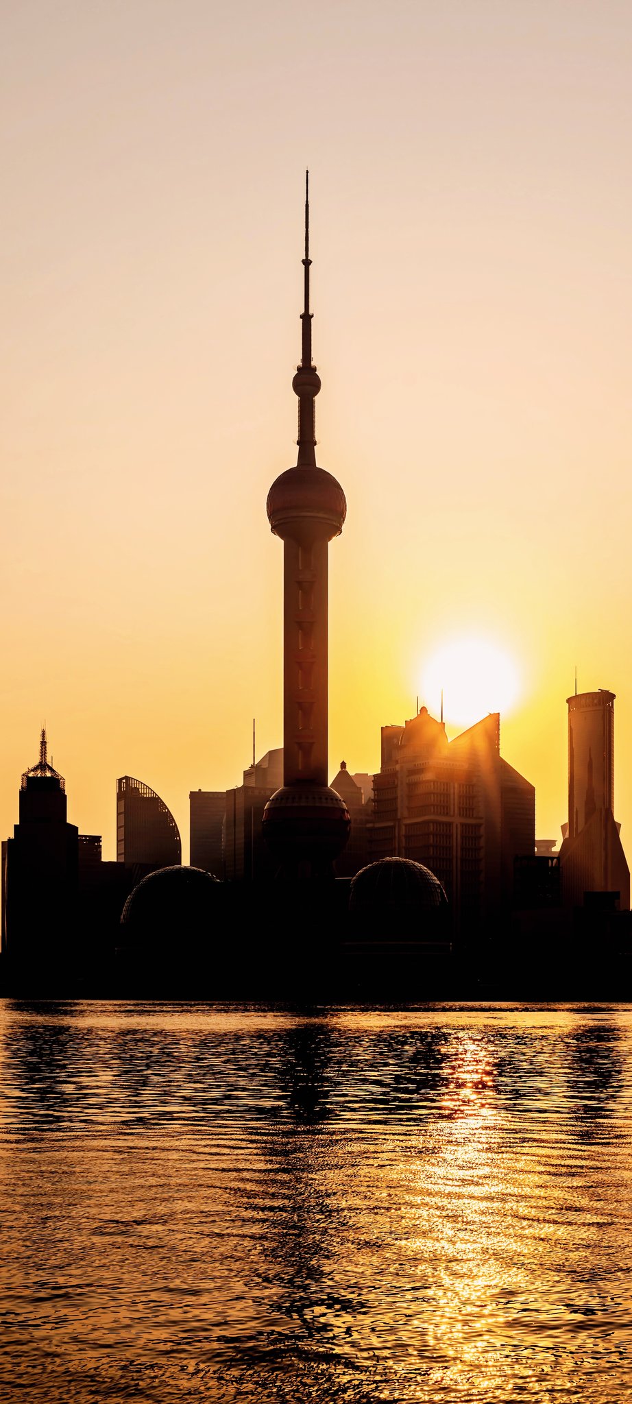 清晨日出光芒照耀中的中国上海黄浦江外滩陆家嘴东方明珠塔城市天际线