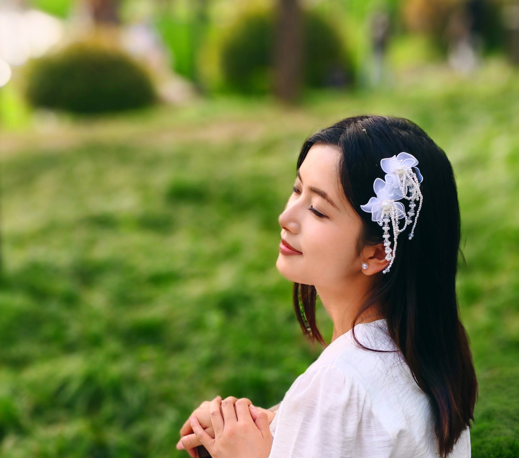 公园里带白色头饰白衣闭眼微笑美女头像