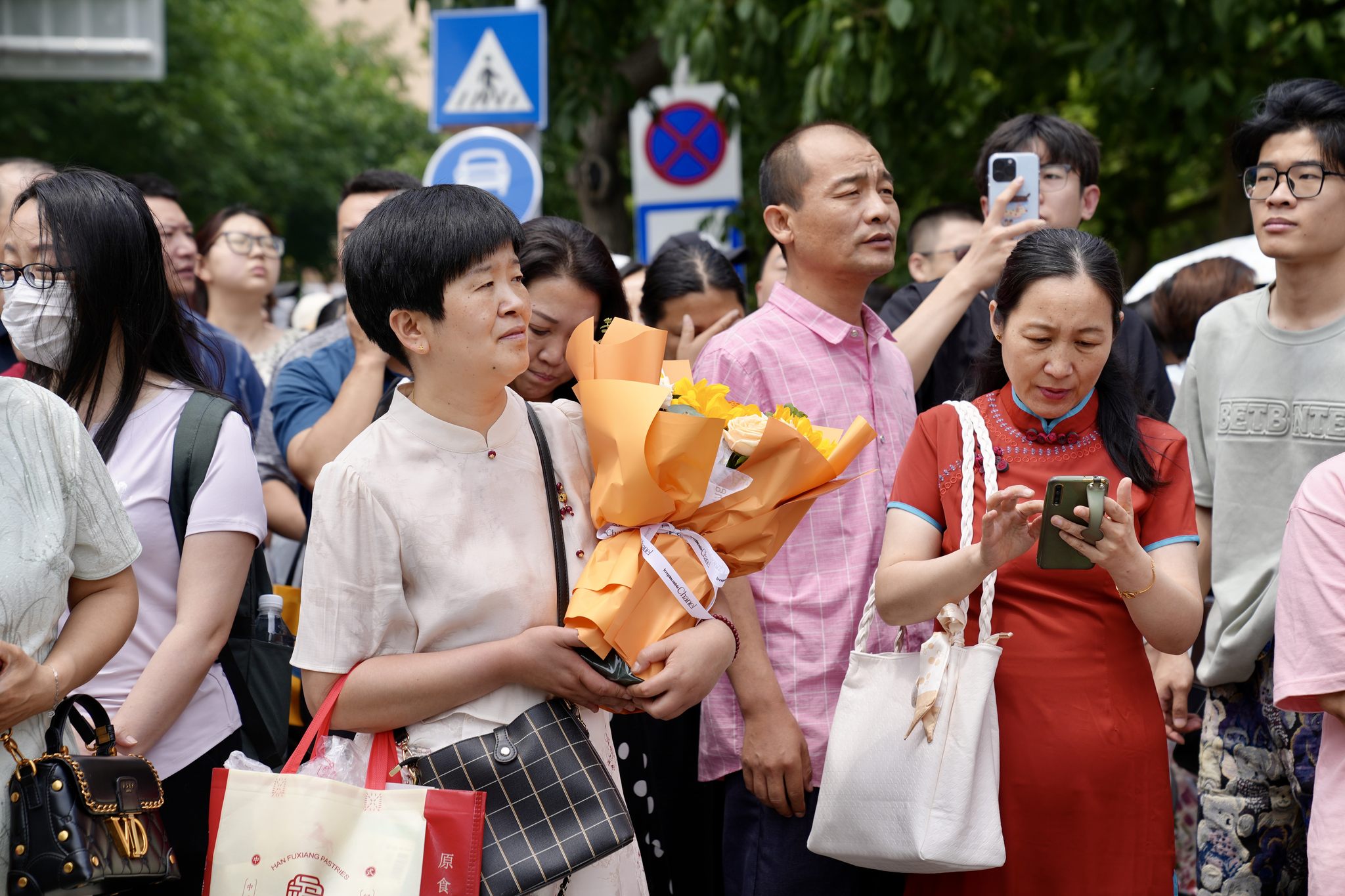 2024高考语文结束,考生陆续走出考场,家长送上鲜花与拥抱