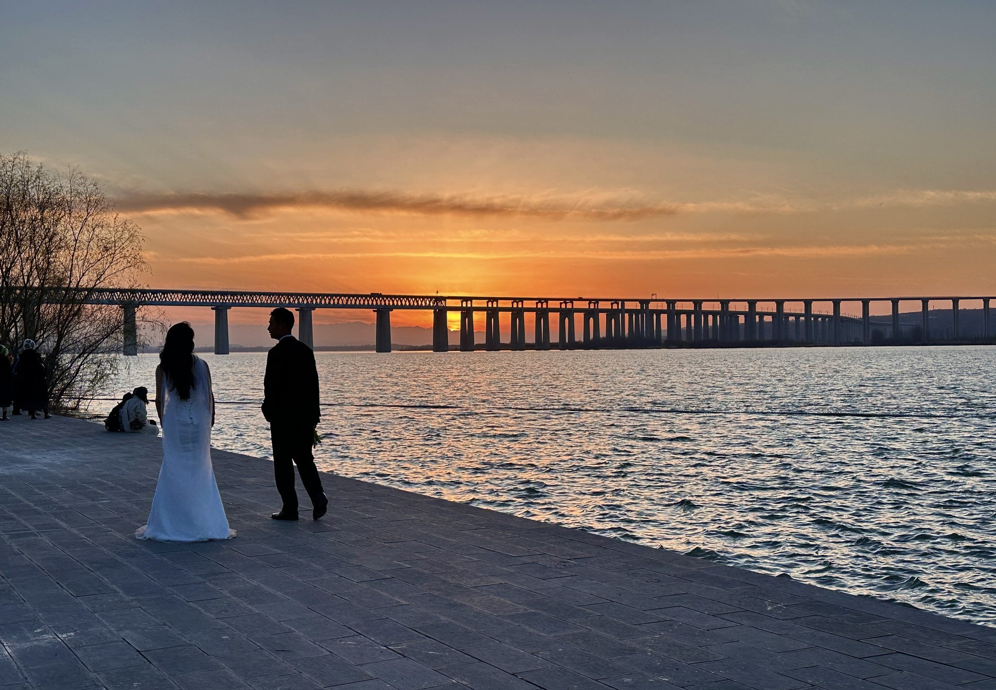 落日一对情侣漫步湖边